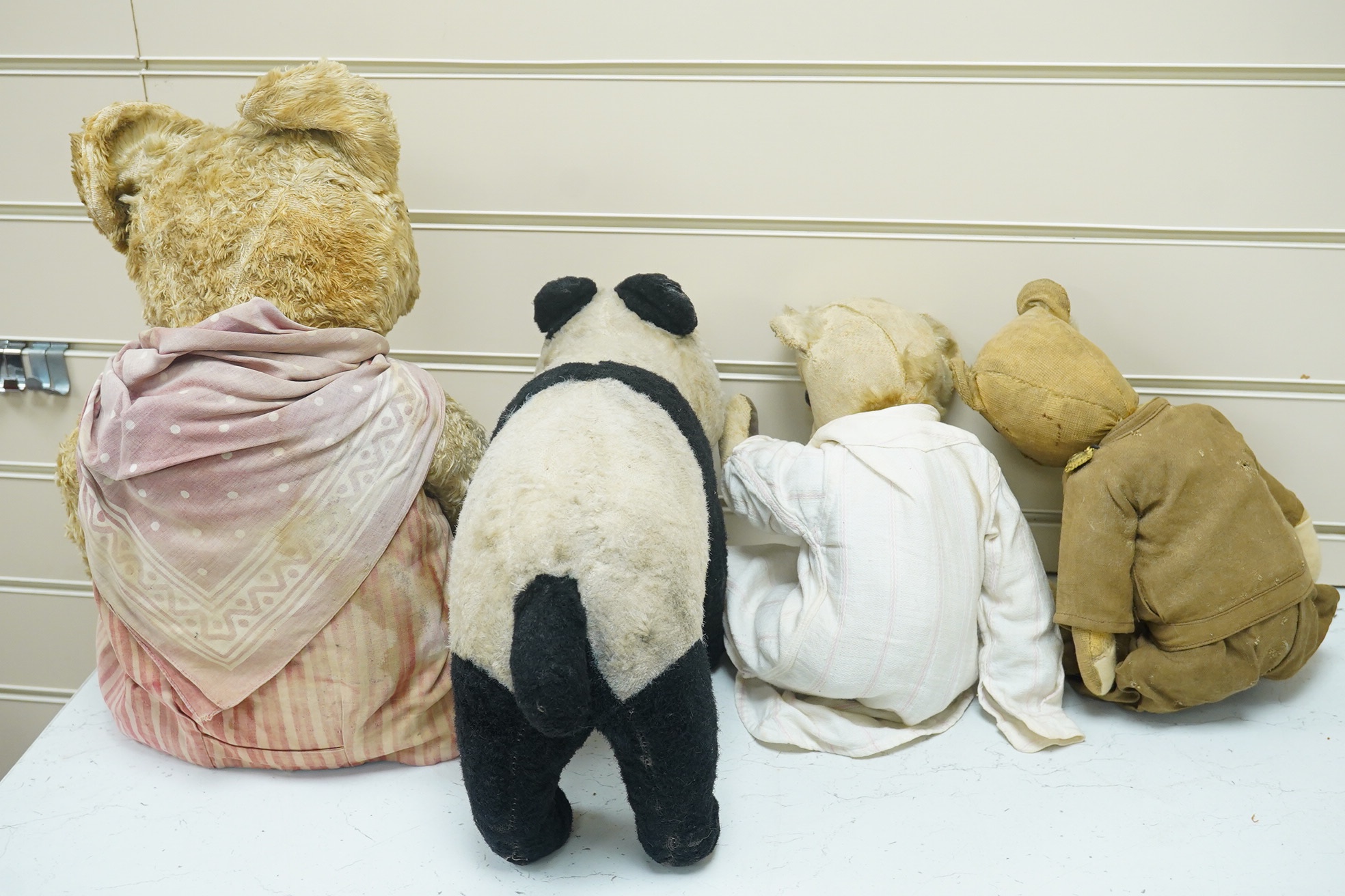 A Panda Invicta bear cotton plush, damage to paw pads, a Merrythought Panda, two other English bears (4). Condition - poor.